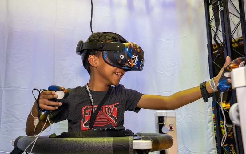 Young guest in a Quest 3 headset playing on the Virtualizer VR treadmill