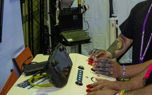 Guests playing on the X-Arcade pedestal with red arcade buttons